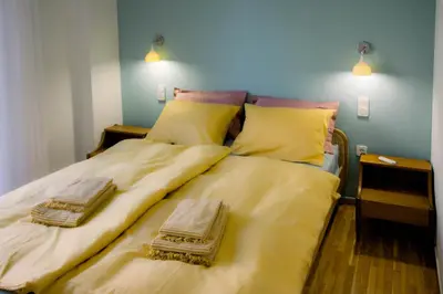 a bed with two blankets and pillows on it at Blue harbour house - style meets comfort in Piraeus