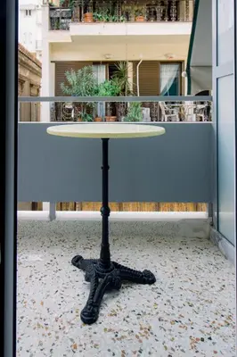 a table sitting on top of a balcony at Blue harbour house - style meets comfort in Piraeus