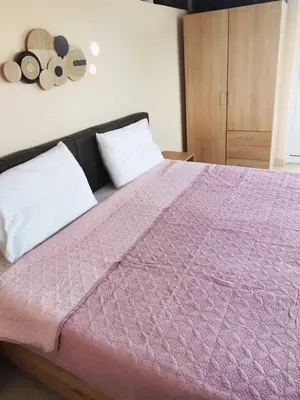 a bedroom with a bed with a pink blanket at Studio with unique view near the beach! in Porto Rafti