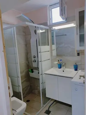 a white bathroom with a toilet and a sink at Studio with unique view near the beach! in Porto Rafti
