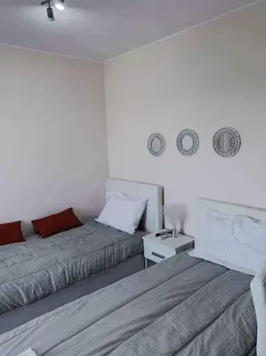 a bedroom with two beds and a night stand with a bedskirts at Studio with unique view near the beach! in Porto Rafti