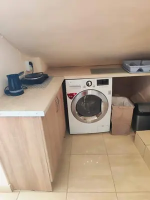 a small kitchen with a washing machine on a counter at Studio with unique view near the beach! in Porto Rafti