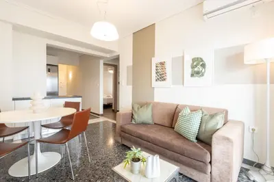 a living room with a couch and a table at Luxury Beachfront Suite in Voula Premium 2-Bedroom Stay in Athens