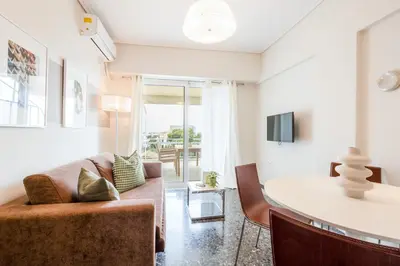 a living room with a couch and a table at Luxury Beachfront Suite in Voula Premium 2-Bedroom Stay in Athens