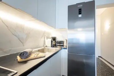 a kitchen with a sink and a refrigerator at Luxury Beachfront Suite in Voula Premium 2-Bedroom Stay in Athens