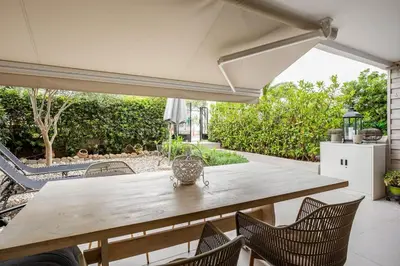 an outdoor table with chairs and an umbrella at Atlantis Riviera Beachfront Fast WiFi in Athens