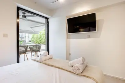 a bedroom with a bed with a tv on the wall at Atlantis Riviera Beachfront Fast WiFi in Athens