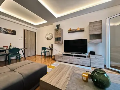 a living room with a large flat screen tv at Acropolis Aria Apartment-Steps to Metro & Tram in Athens