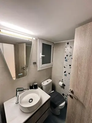 a bathroom with a sink and a toilet and a mirror at Acropolis Aria Apartment-Steps to Metro & Tram in Athens