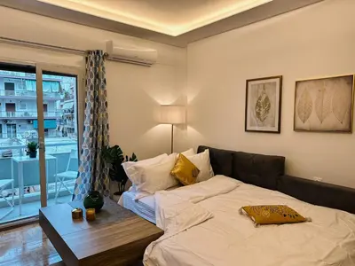 a bedroom with a bed and a large window at Acropolis Aria Apartment-Steps to Metro & Tram in Athens