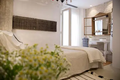 a bedroom with a bed and a window and flowers at Boutique apartment near Acropolis in Athens