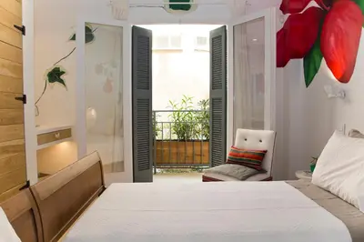 a bedroom with a bed and a chair and a window at Boutique apartment near Acropolis in Athens
