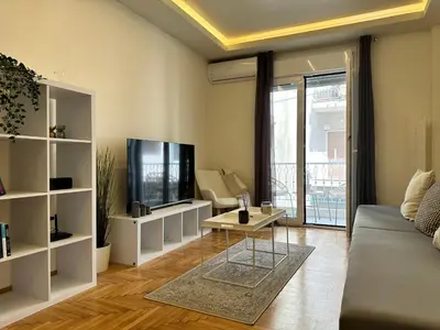 a living room with a couch and a tv at Kypseli Contemporary Comfort for 6 in Athens