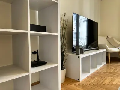 a living room with white shelves and a tv at Kypseli Contemporary Comfort for 6 in Athens