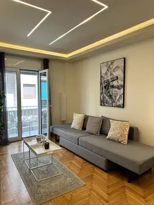 a living room with a couch and a table at Kypseli Contemporary Comfort for 6 in Athens