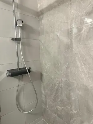 a shower with a hose in a bathroom at Kypseli Contemporary Comfort for 6 in Athens