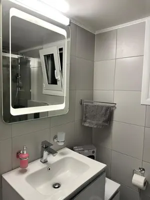 a white bathroom with a sink and a mirror at Kypseli Contemporary Comfort for 6 in Athens