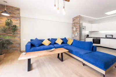 a living room with a blue couch and a table at Three Bedroom Stylish Apt next to Acropolis in Athens