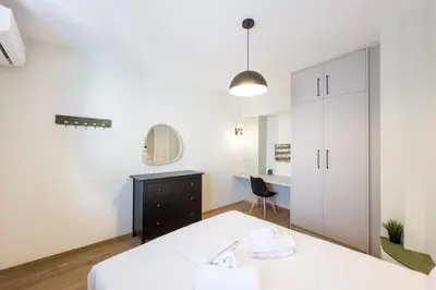 a bedroom with a bed and a desk and a mirror at Three Bedroom Stylish Apt next to Acropolis in Athens
