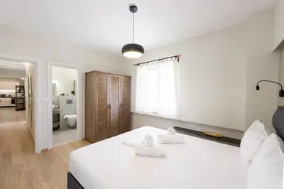 a bedroom with a white bed and a bathroom at Three Bedroom Stylish Apt next to Acropolis in Athens