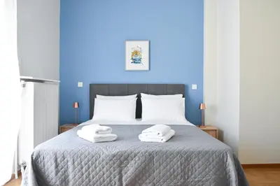 a blue bedroom with a bed with two towels on it at Spacious apartment in Athens in Athens