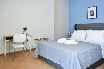 a bedroom with a bed with a desk and a chair at Spacious apartment in Athens in Athens