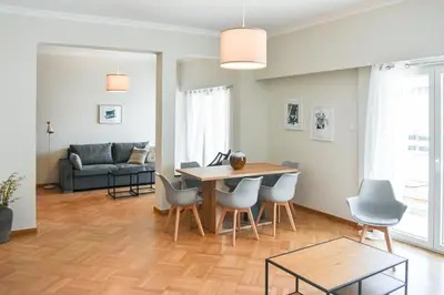 a living room with a table and chairs and a couch at Spacious apartment in Athens in Athens