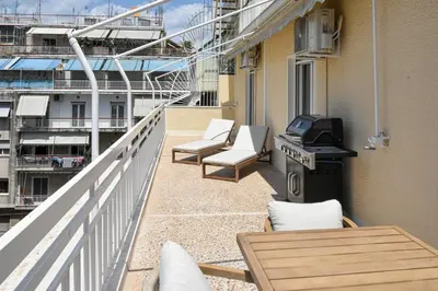 a balcony with chairs and a grill on a building at Spacious apartment in Athens in Athens