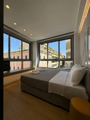 a bedroom with a large bed and large windows at PortStay - Complex N71 in Piraeus