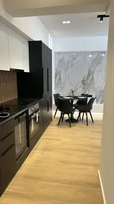a kitchen with black cabinets and a table with chairs at PortStay - Complex N71 in Piraeus
