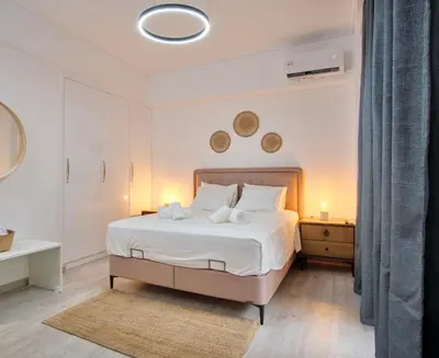 a white bedroom with a large bed and a table at Central Cozy House in Athens