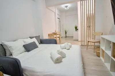 a bedroom with a white bed with towels on it at Central Cozy House in Athens
