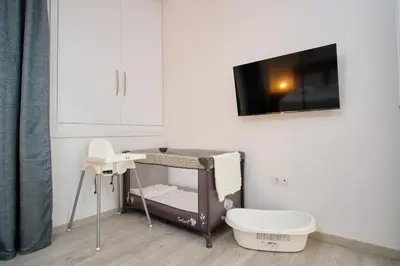 a bathroom with a toilet and a tv on a wall at Central Cozy House in Athens