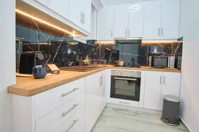 a kitchen with white cabinets and a stove top oven at Central Cozy House in Athens