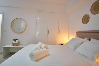 a bedroom with a white bed with towels on it at Central Cozy House in Athens