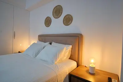 a bedroom with a bed and a night stand with a candle at Central Cozy House in Athens