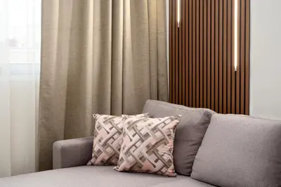 a couch with a pillow in front of a curtain at Elegant Zen 2BR Apartment in Athens in Athens