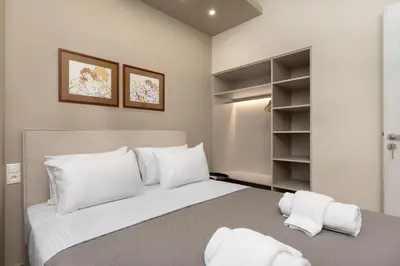 a bedroom with a large bed with white pillows at Elegant Comfort 2BR Apartment in Athens in Athens