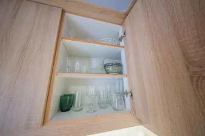 a cabinet with glasses and other items in it at Lux Apartment next to the sea in Piraeus