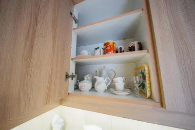 a cupboard with a bunch of ceramics on it at Lux Apartment next to the sea in Piraeus