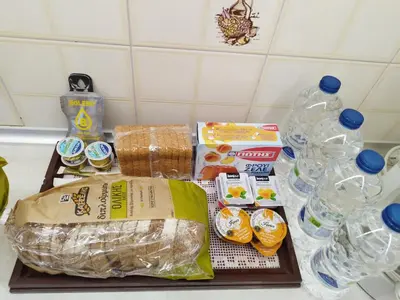 a counter with a tray of food and bottles of water at Lux Apartment next to the sea in Piraeus