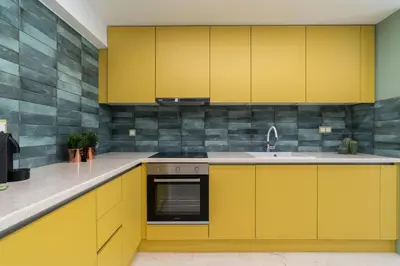 a kitchen with yellow cabinets and a sink at Elegant Escape 2BR BA Sunny Apt in Athens