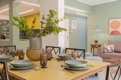 a dining room with a table with plates and utensils at Elegant Escape 2BR BA Sunny Apt in Athens