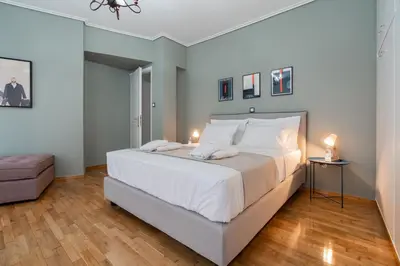 a bedroom with a large white bed with two lamps at Elegant Escape 2BR BA Sunny Apt in Athens