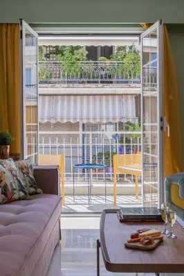 a living room with a couch and a large window at Elegant Escape 2BR BA Sunny Apt in Athens