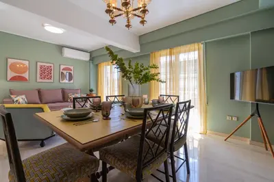 a dining room with a table and a couch at Elegant Escape 2BR BA Sunny Apt in Athens
