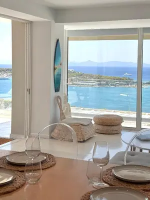 a dining room with a view of the ocean at Dream View Vouliagmeni in Athens
