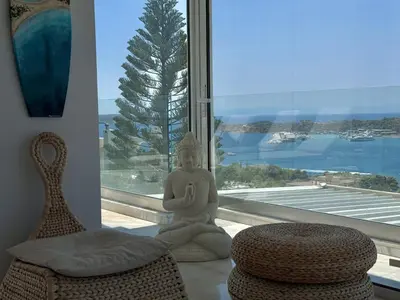 a room with a statue of a meditating person next to a window at Dream View Vouliagmeni in Athens