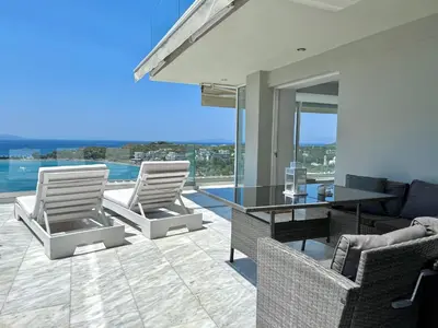 a living room with two chairs and a table at Dream View Vouliagmeni in Athens
