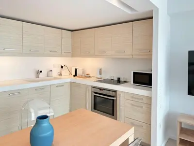 a kitchen with wooden cabinets and a blue vase on a table at Dream View Vouliagmeni in Athens